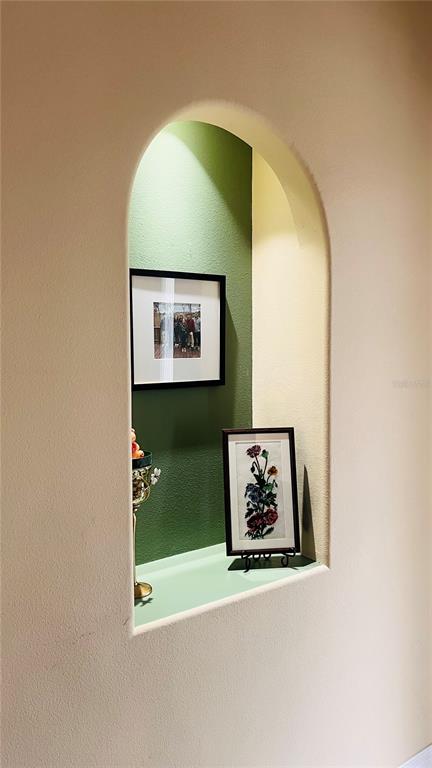 An arched wall niche features a green back wall, a shelf, and two framed pictures — 727 ALDENWOOD TRAIL, NEW SMYRNA BEACH, FL