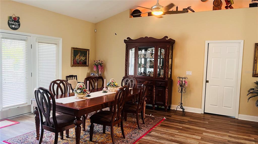 A dining room features a wooden table, chairs, a large hutch, and wood-look flooring — 727 ALDENWOOD TRAIL, NEW SMYRNA BEACH, FL
