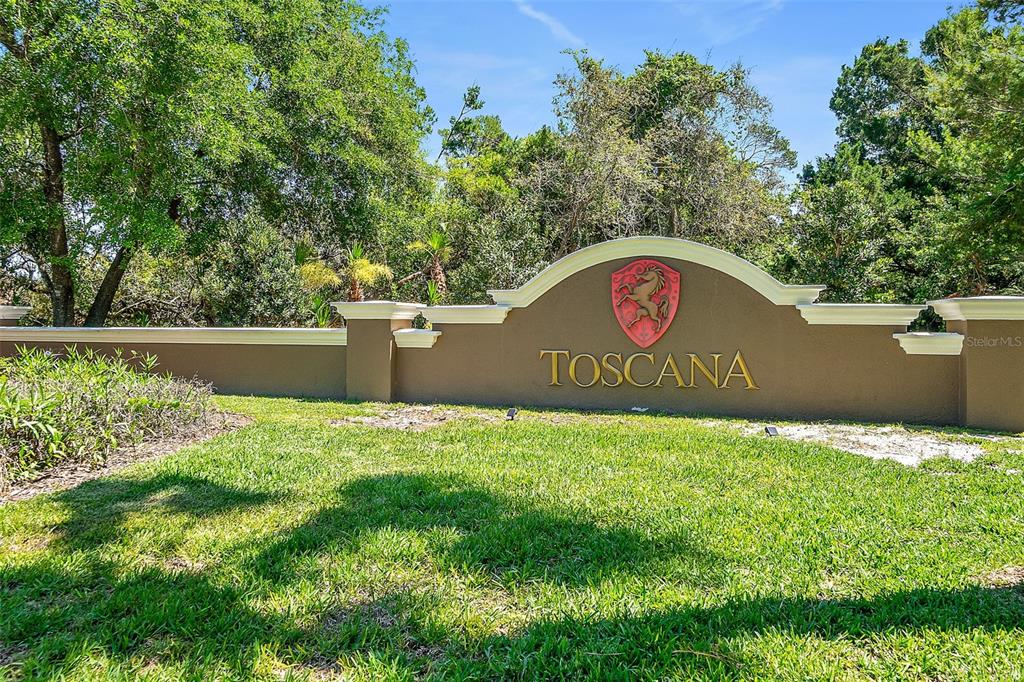 A brown monument sign with the name Toscana sits in front of trees and grass — 74 NEW LEATHERWOOD DRIVE, PALM COAST, FL