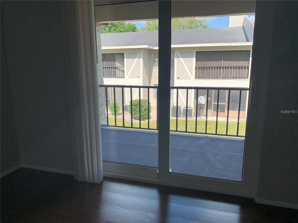 A view from inside a room through a sliding glass door onto a balcony — 14402 REUTER STRASSE CIRCLE UNIT #2, TAMPA, FL