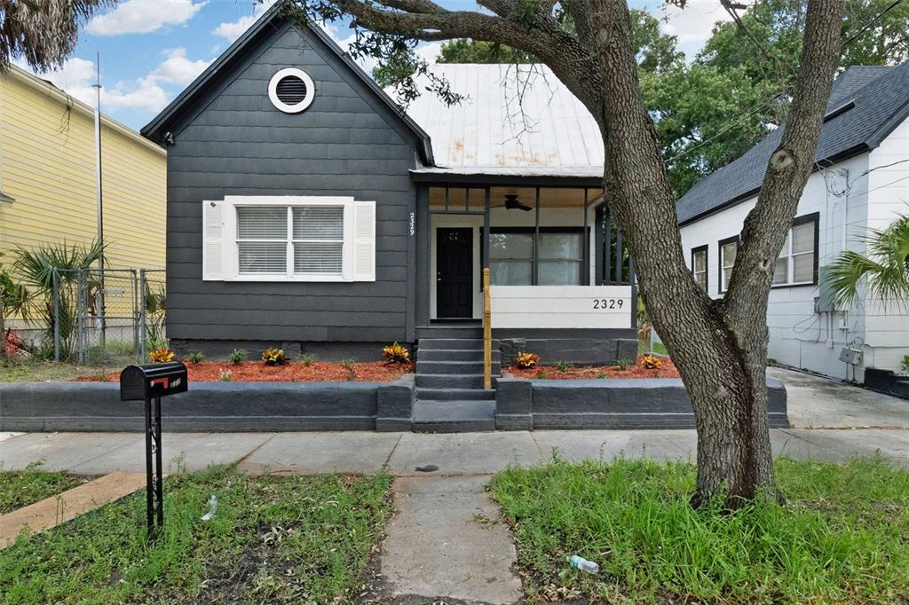 A dark gray cottage with a white metal roof and a small front porch — 2329 W BEACH STREET, TAMPA, FL