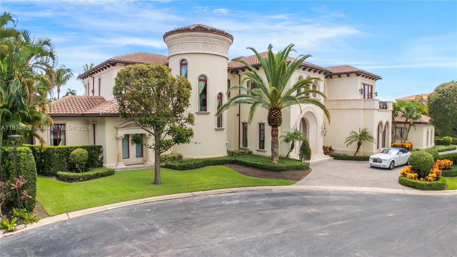 A large Mediterranean-style mansion with a central turret and a white convertible in the driveway — 700 Osprey Point Cir, Boca Raton FL 33431, BOCA RATON, FL