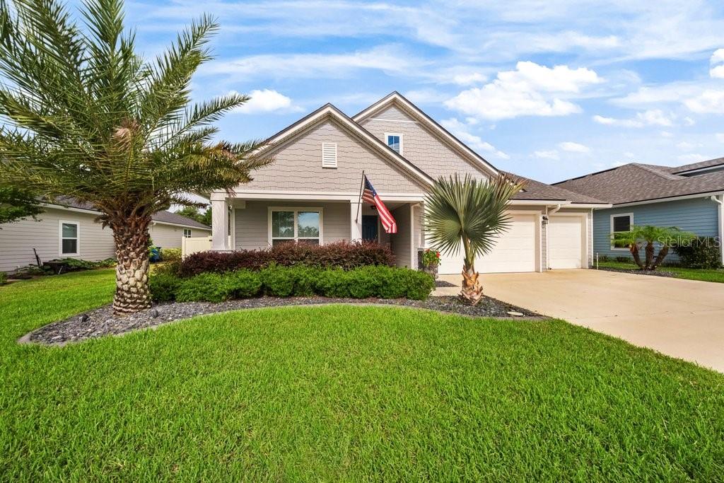 A single-story house with gray siding, a two-car garage, and a front yard with palms — 338 WILLOW LAKE DRIVE, ST AUGUSTINE, FL