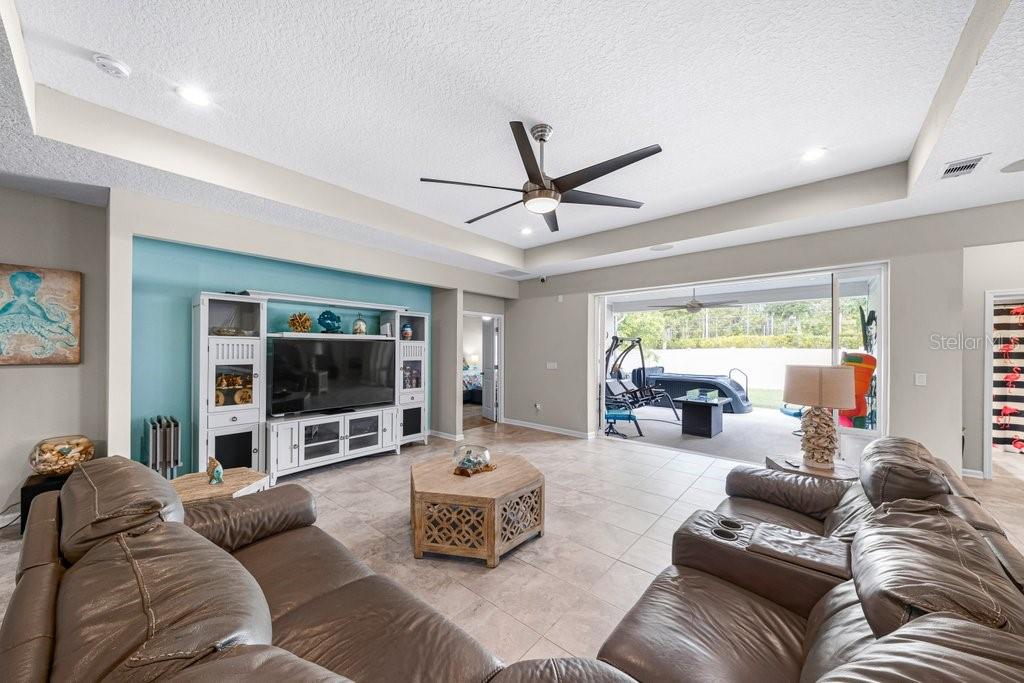 A living room with tile floors, a ceiling fan, and sliding doors opening to a patio — 338 WILLOW LAKE DRIVE, ST AUGUSTINE, FL