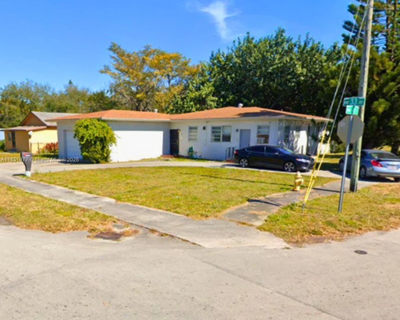 A single-story house with a light-colored exterior, a brown roof, and a front lawn — 4501 NW 33rd Ave, Miami FL 33142, MIAMI, FL