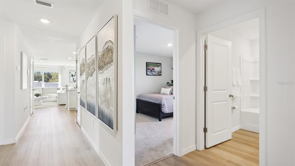 A hallway leads to a living area, a bedroom, and a bathroom with light flooring — 1013 GUM SPRING COURT, RUSKIN, FL