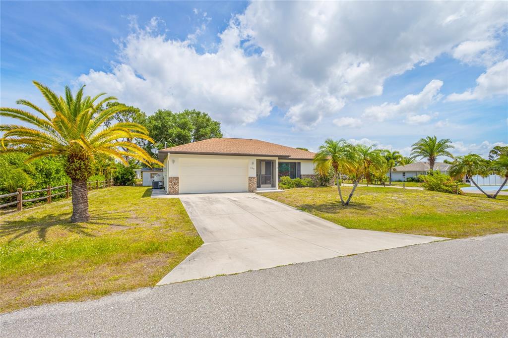 A single-story house with a two-car garage, a concrete driveway, and several palm trees — 420 DUKE ROAD, VENICE, FL