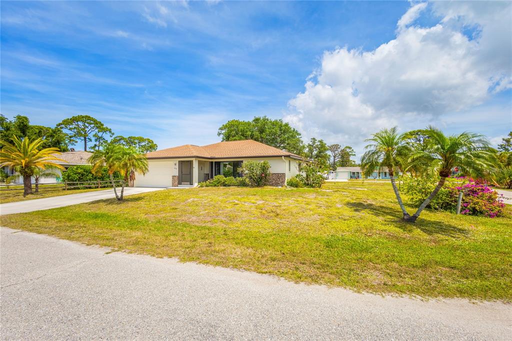 A single-story house with a tan roof and light-colored siding sits on a grassy lot — 420 DUKE ROAD, VENICE, FL