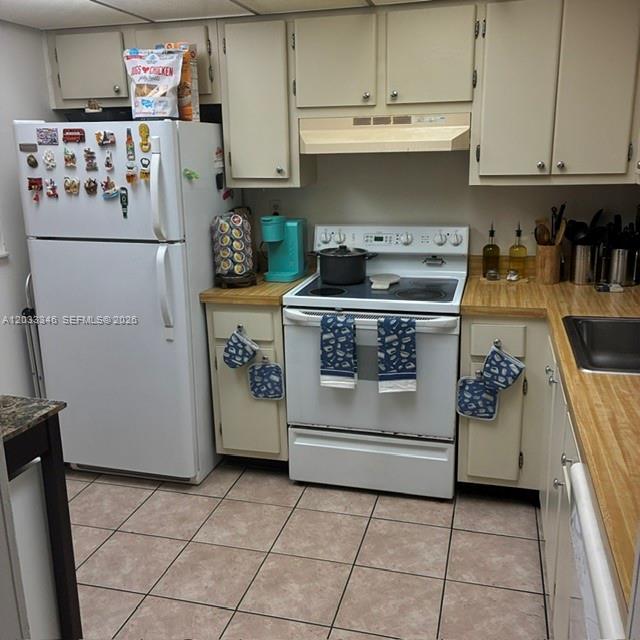 A kitchen features white appliances, light-colored cabinets, a wood-look laminate countertop, and tiled flooring — 10845 SW 112th Ave, Miami FL 33176, MIAMI, FL