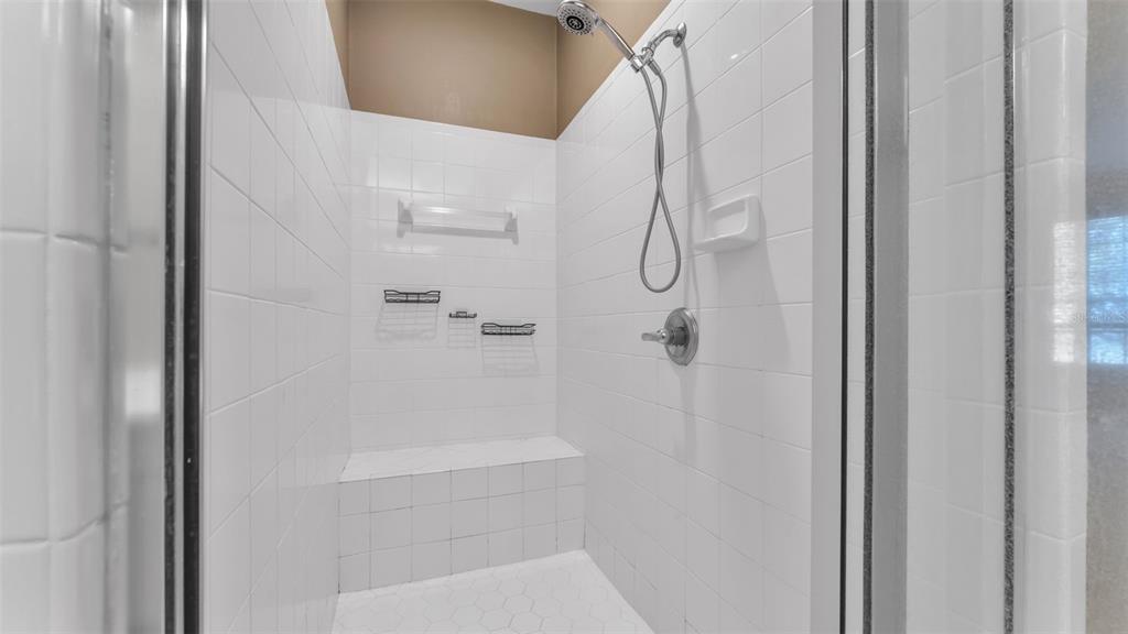 A walk-in shower features white subway tile walls, a built-in bench, and a handheld sprayer — 386 ENCLAVE DRIVE UNIT 386, LAKELAND, FL