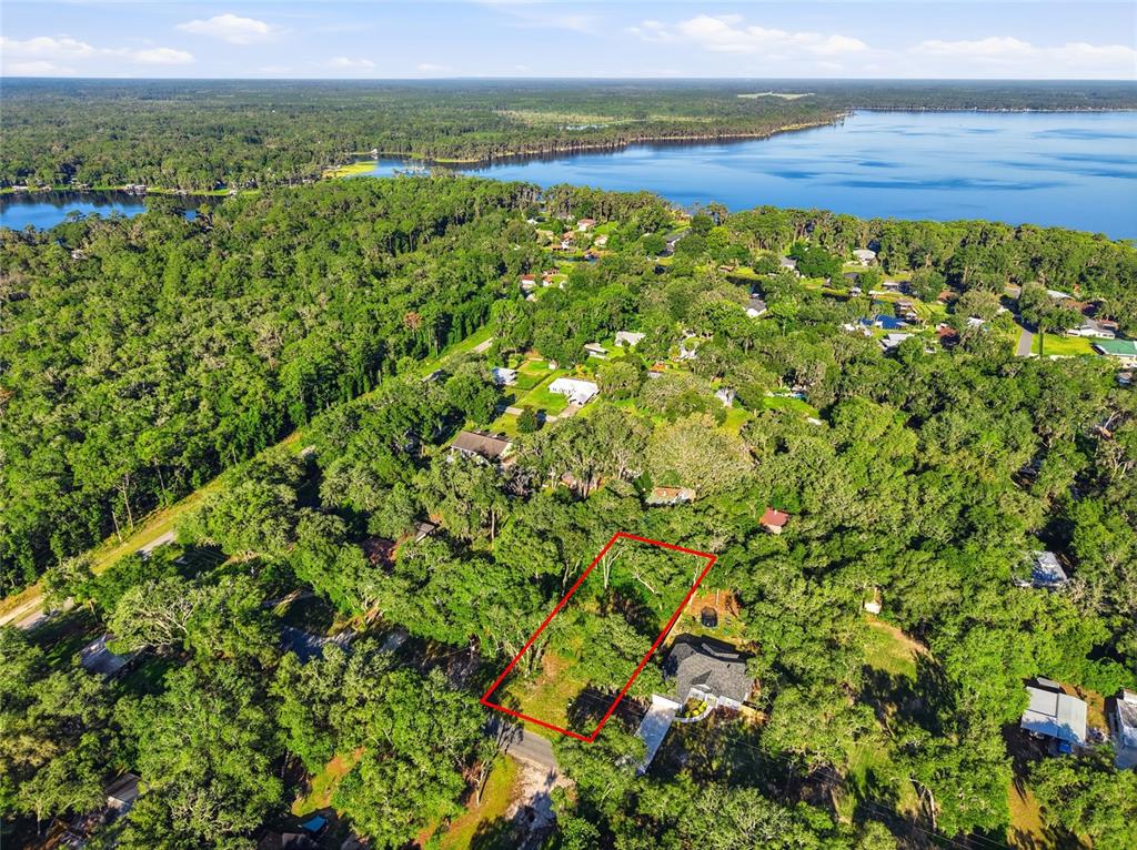 An aerial view shows a rectangular vacant lot outlined in red within a wooded neighborhood — 00 SE 2ND AVENUE, MELROSE, FL