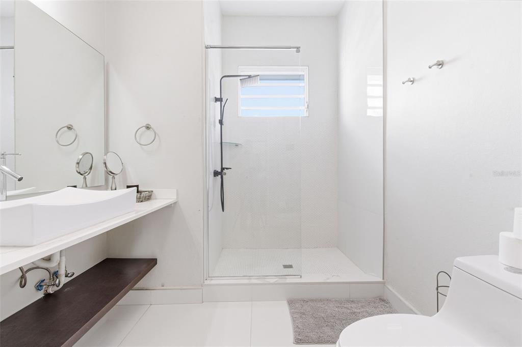 A modern bathroom features a white vessel sink, a walk-in shower, and a toilet — 56 CALLE F KRUG CONDADO UNIT PH-1, SAN JUAN, PR