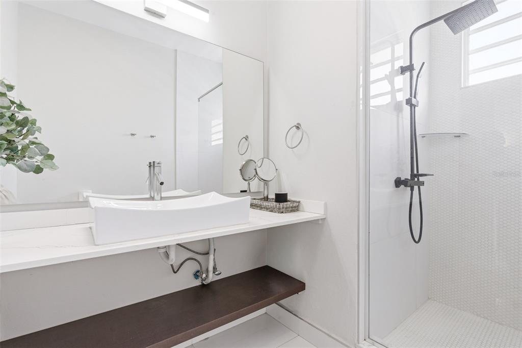A modern bathroom features a white vessel sink, a floating shelf, and a glass shower — 56 CALLE F KRUG CONDADO UNIT PH-1, SAN JUAN, PR
