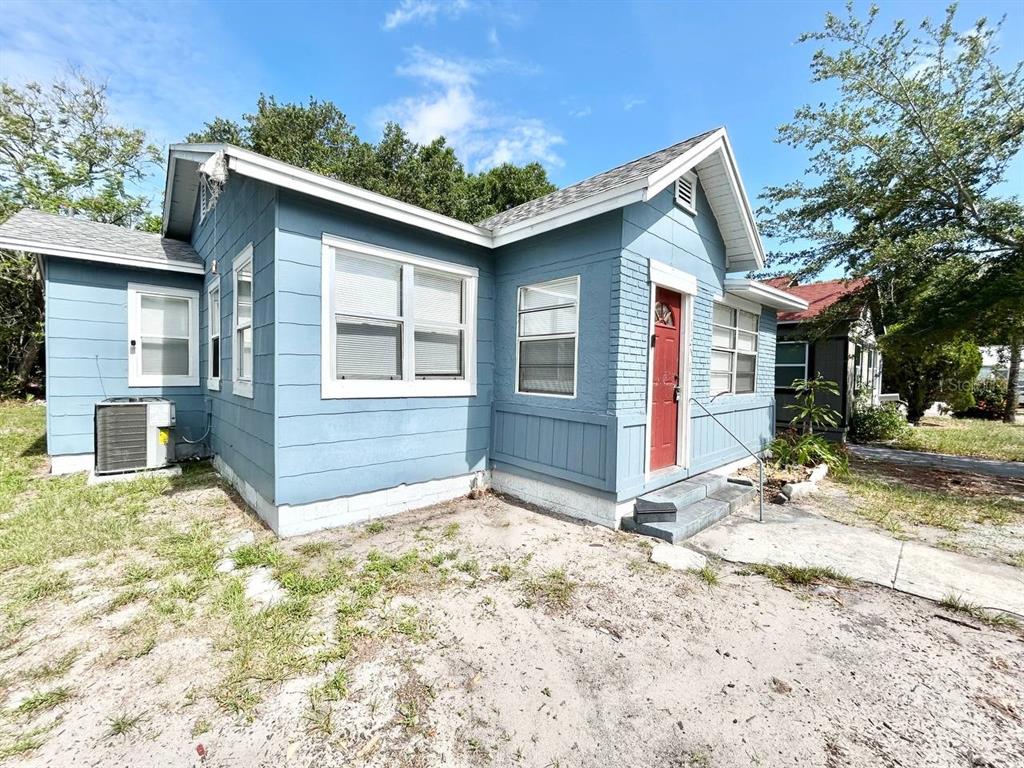 A blue-painted house with a red front door and an exterior air conditioning unit — 1311 PRESCOTT STREET S, ST PETERSBURG, FL