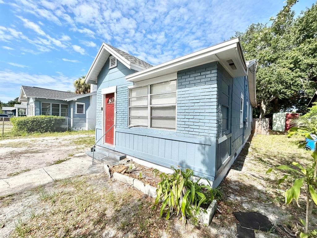 A blue painted brick house with a red front door and a small front yard — 1311 PRESCOTT STREET S, ST PETERSBURG, FL