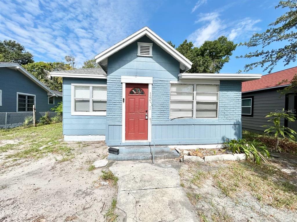 A blue, single-story house with a red front door and a concrete walkway — 1311 PRESCOTT STREET S, ST PETERSBURG, FL