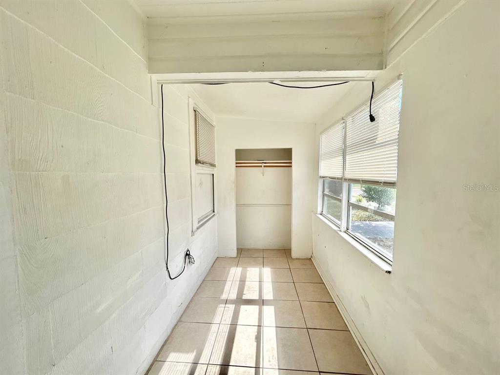 A sunroom with white walls, tiled flooring, a closet, and windows with blinds — 1311 PRESCOTT STREET S, ST PETERSBURG, FL