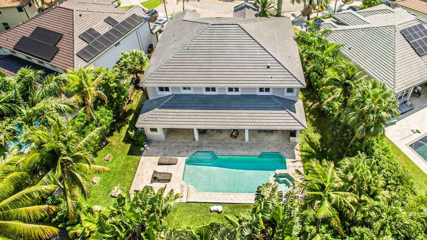 An aerial view of a two-story house with a tiled roof, pool, and patio area — 1879 Hidden Trail Lane, Weston FL 33327, WESTON, FL