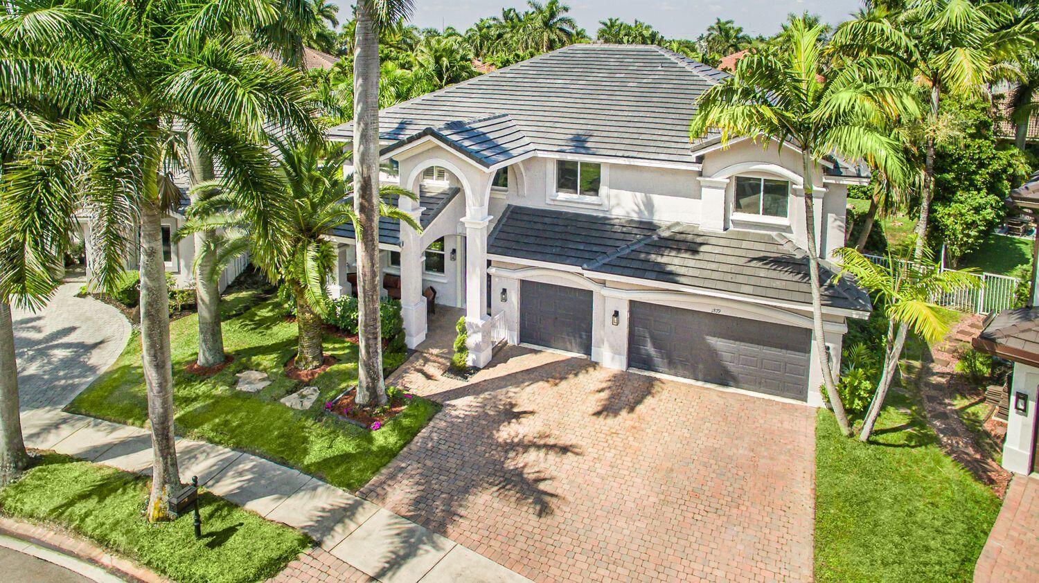 An aerial view of a two-story house with a tiled roof and a brick driveway — 1879 Hidden Trail Lane, Weston FL 33327, WESTON, FL