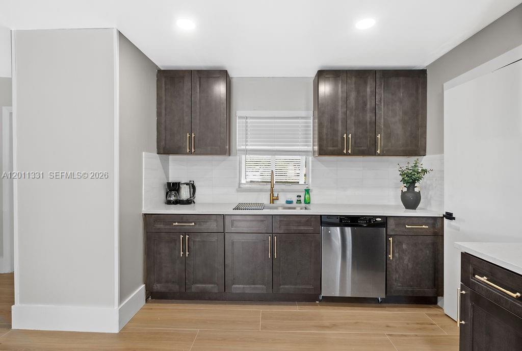 A kitchen features dark wood cabinets, stainless steel appliances, and light-colored countertops — 736 Prosperity Farms Rd, North Palm Beach FL 33408, NORTH PALM BEACH, FL