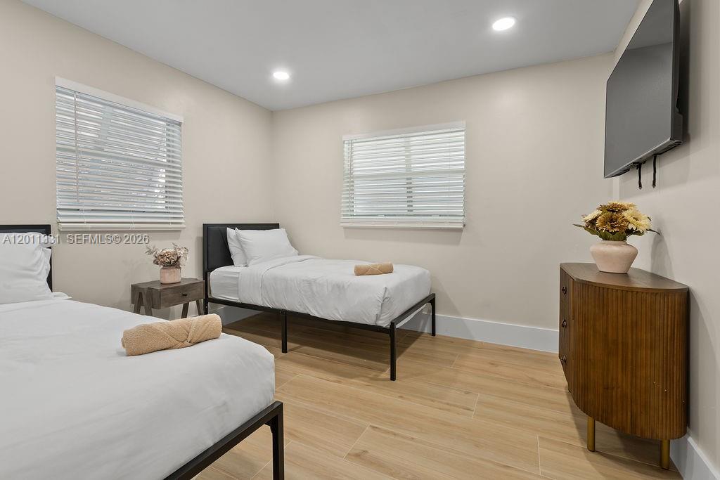 A bedroom features two twin beds, a wooden dresser, and two windows with blinds — 736 Prosperity Farms Rd, North Palm Beach FL 33408, NORTH PALM BEACH, FL