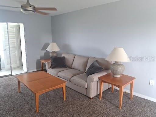 A living room features a beige sofa, two wooden end tables with lamps, and a coffee table — 5245 AMULET DRIVE UNIT 309, NEW PORT RICHEY, FL