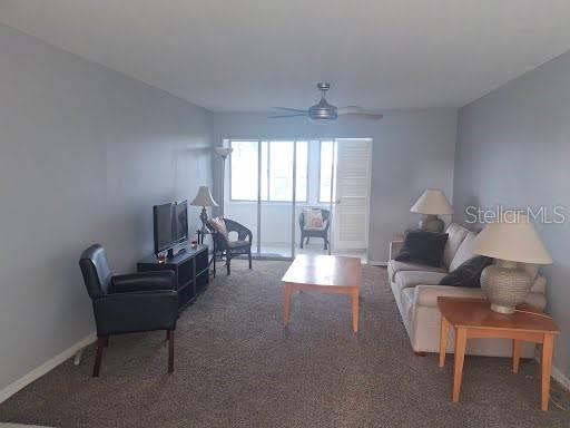 A living room features gray walls, carpeted flooring, a ceiling fan, and a beige sofa — 5245 AMULET DRIVE UNIT 309, NEW PORT RICHEY, FL