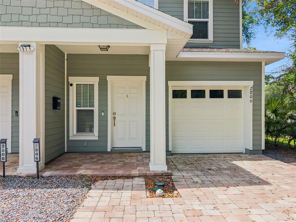 The exterior of a two-story house features green siding, a white door, and a garage — 2806 KILGORE STREET, ORLANDO, FL