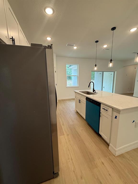 A kitchen features a large island with a sink, white cabinets, and light wood flooring — 1659 W BELEN DRIVE, CITRUS SPRINGS, FL