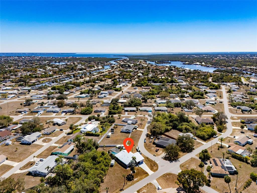 An aerial view shows a residential neighborhood with a red location pin on a house — 643 BLUE LANE NW, PORT CHARLOTTE, FL
