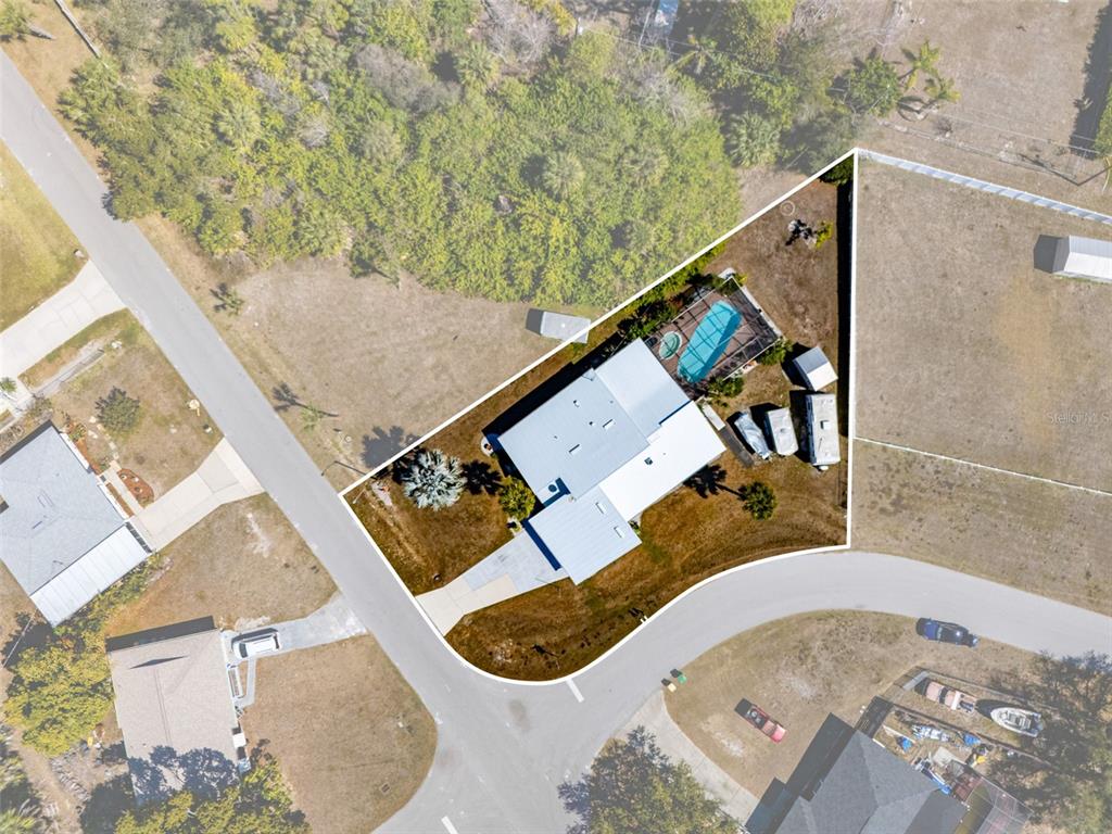 An aerial view shows a house with a pool and a large yard — 643 BLUE LANE NW, PORT CHARLOTTE, FL