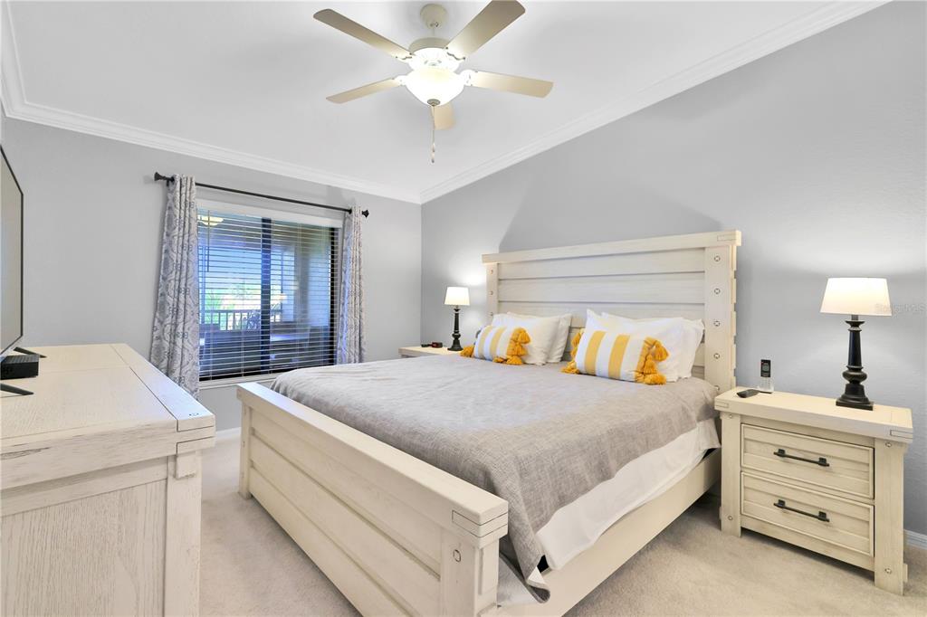 A bedroom features a white wooden bed frame, matching nightstands, and a ceiling fan — 5634 PALMER CIRCLE UNIT 203, BRADENTON, FL