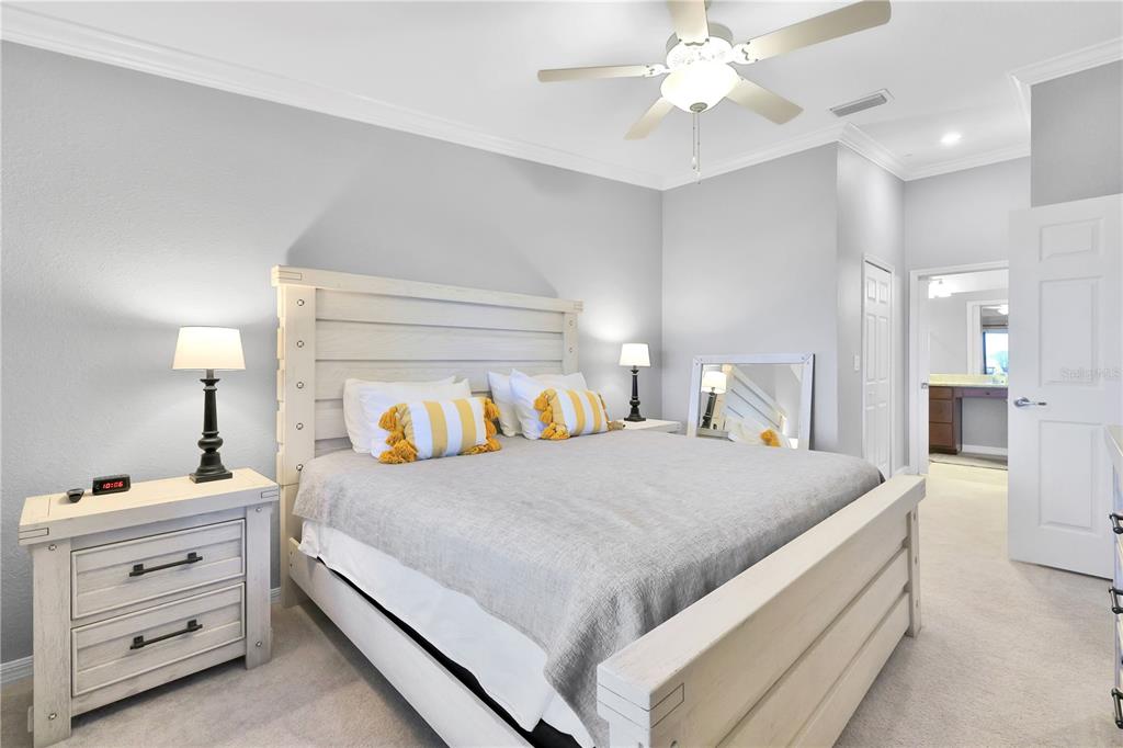 A bedroom features a white wooden bed frame, two nightstands, and a ceiling fan — 5634 PALMER CIRCLE UNIT 203, BRADENTON, FL