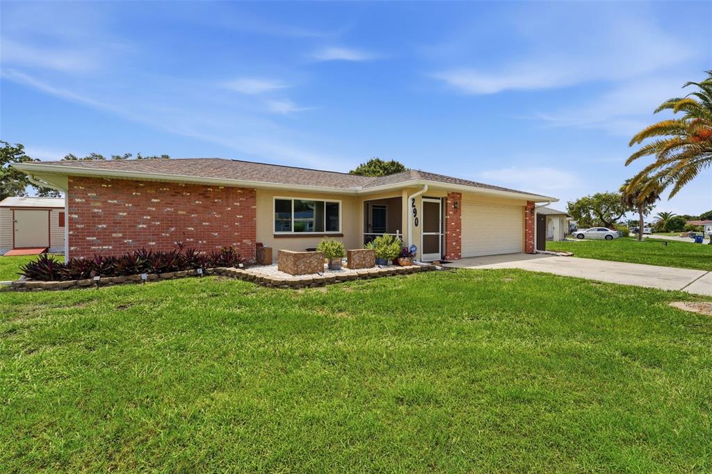 A single-story brick and stucco house with a two-car garage and a front lawn — 290 CAPRI AVENUE, VENICE, FL