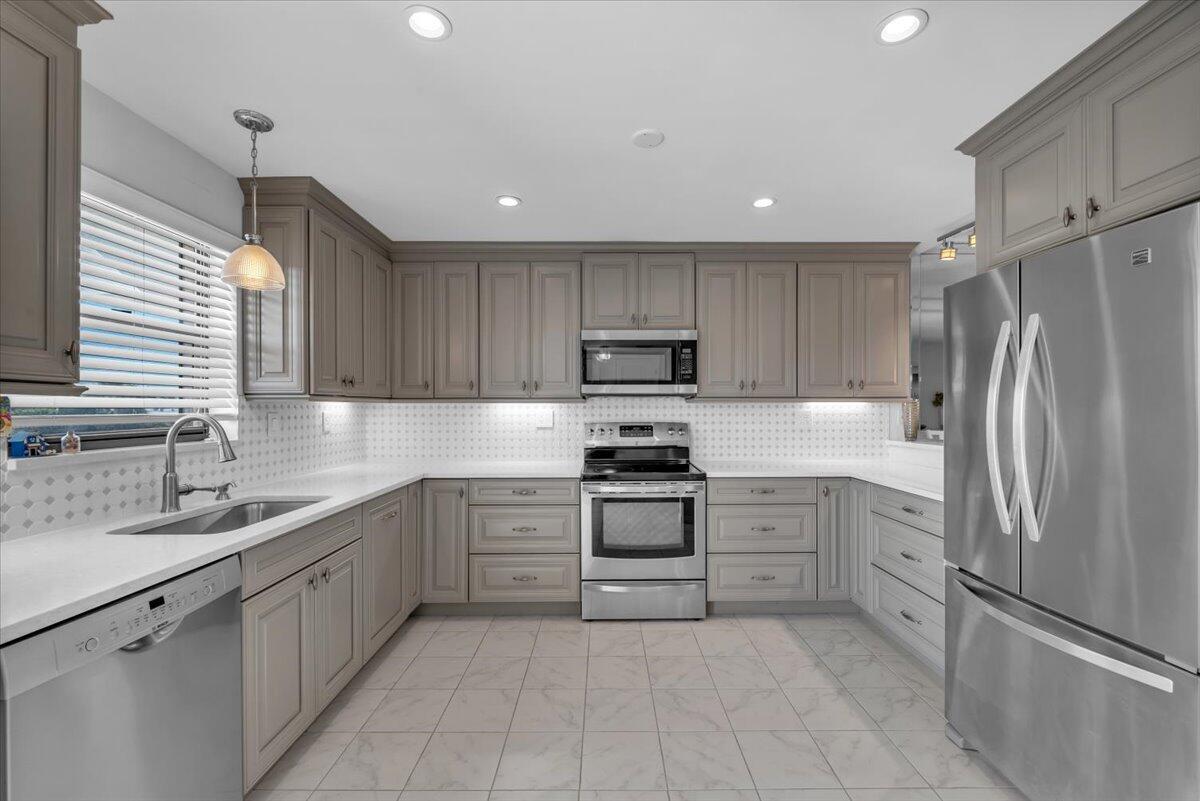 A kitchen with gray cabinets, stainless steel appliances, white countertops, and a tiled floor — 300 N Highway A1a # 304h, Jupiter FL 33477, JUPITER, FL