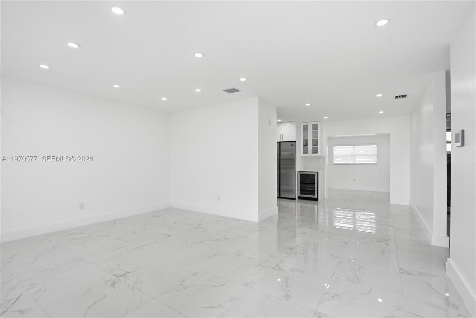 A bright, open-concept room features white walls, recessed lighting, and polished marble-look tile flooring — 5521 SW 104th Ave, Miami FL 33165, MIAMI, FL