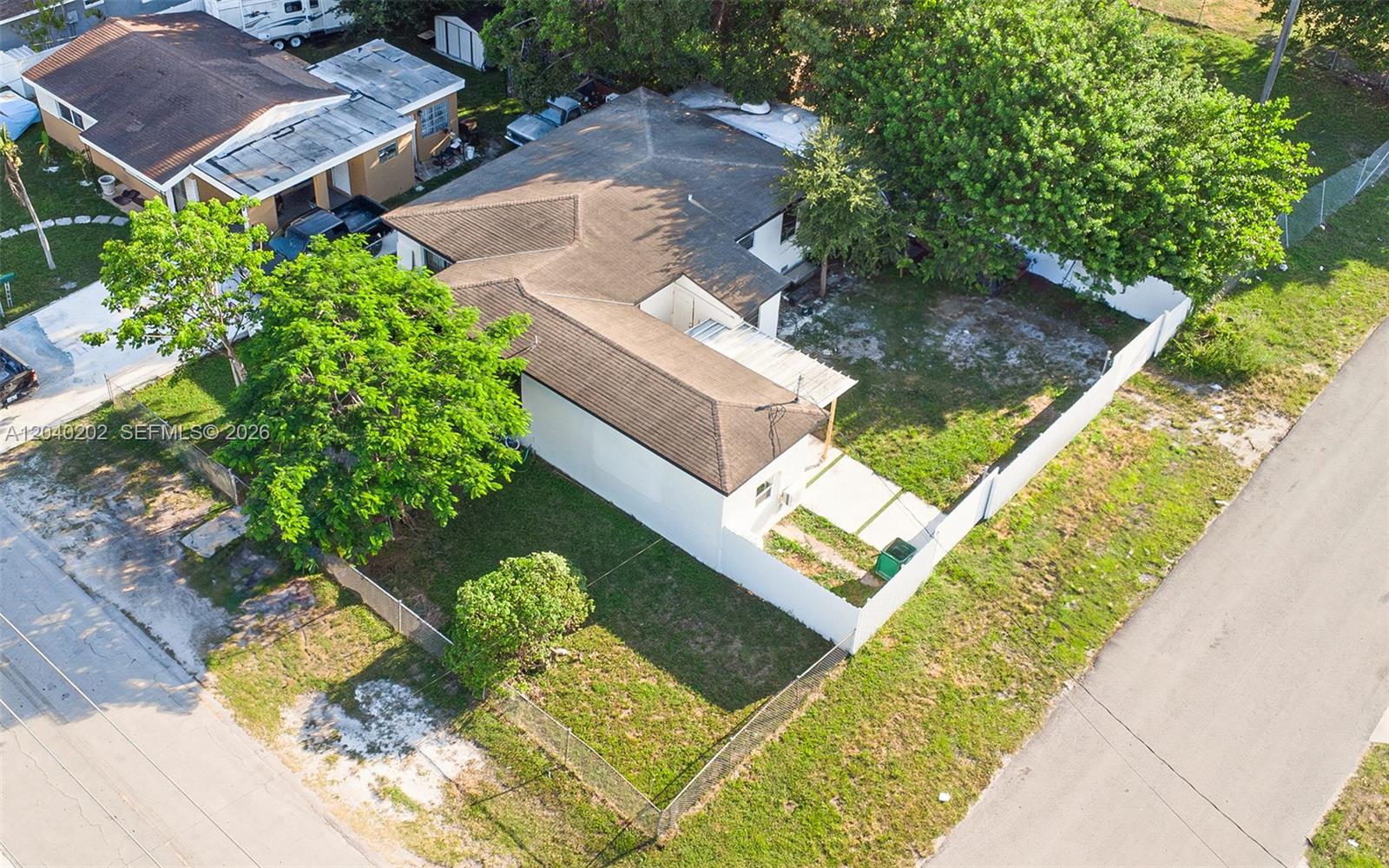 An aerial view shows a single-story house with a fenced yard and mature trees — 7190 NW 21st Ave, Miami FL 33147, MIAMI, FL