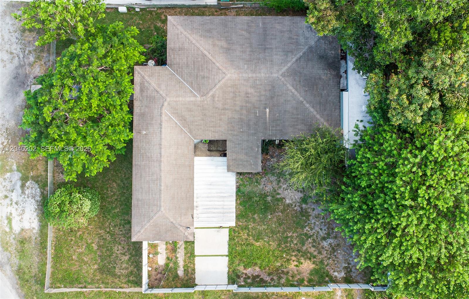 An aerial view shows a house with a shingled roof, a carport, and surrounding trees — 7190 NW 21st Ave, Miami FL 33147, MIAMI, FL