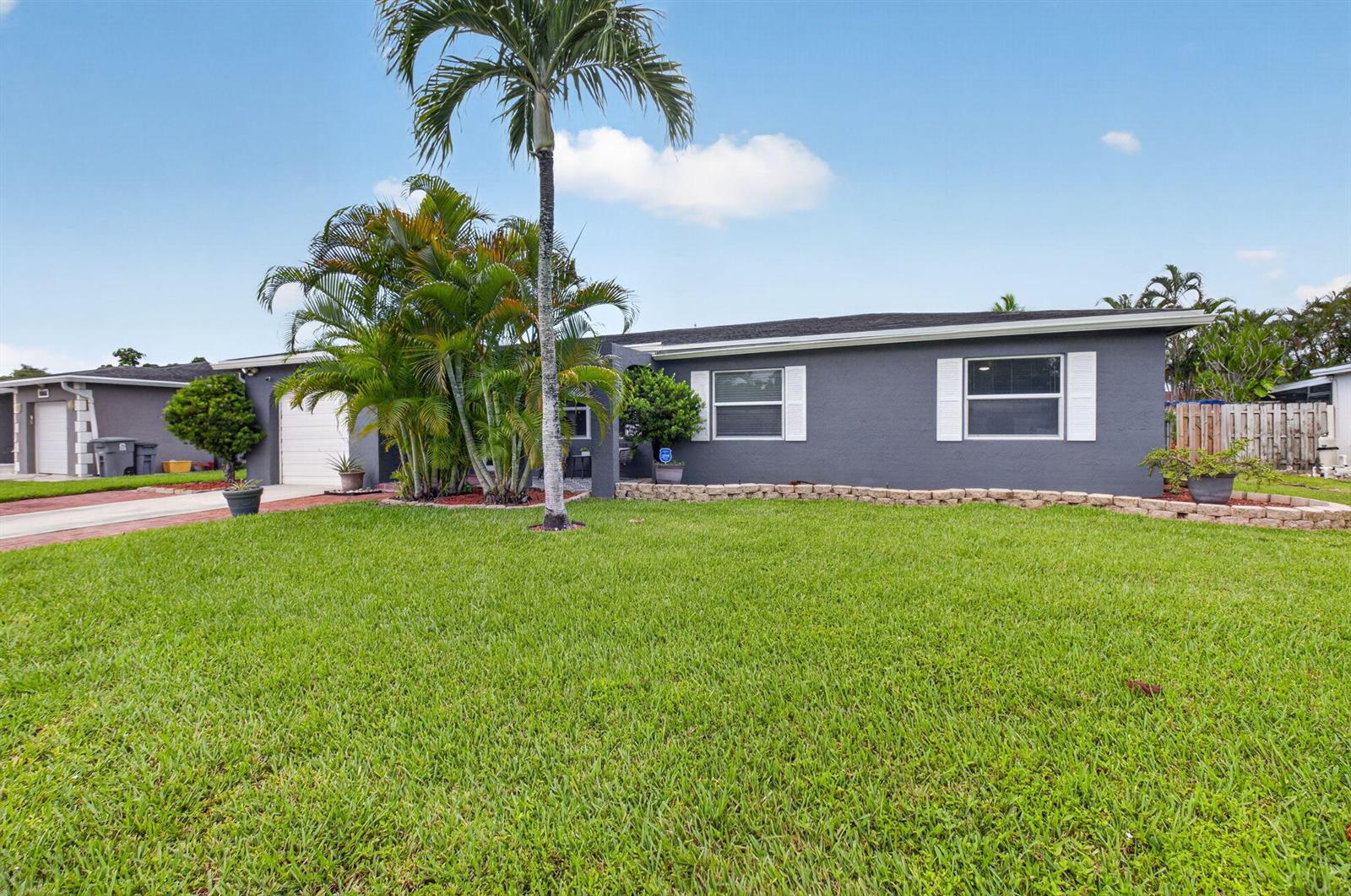 A single-story gray house with a palm tree, a front lawn, and a garage — 4599 Betelnut Street, Boca Raton FL 33428, BOCA RATON, FL