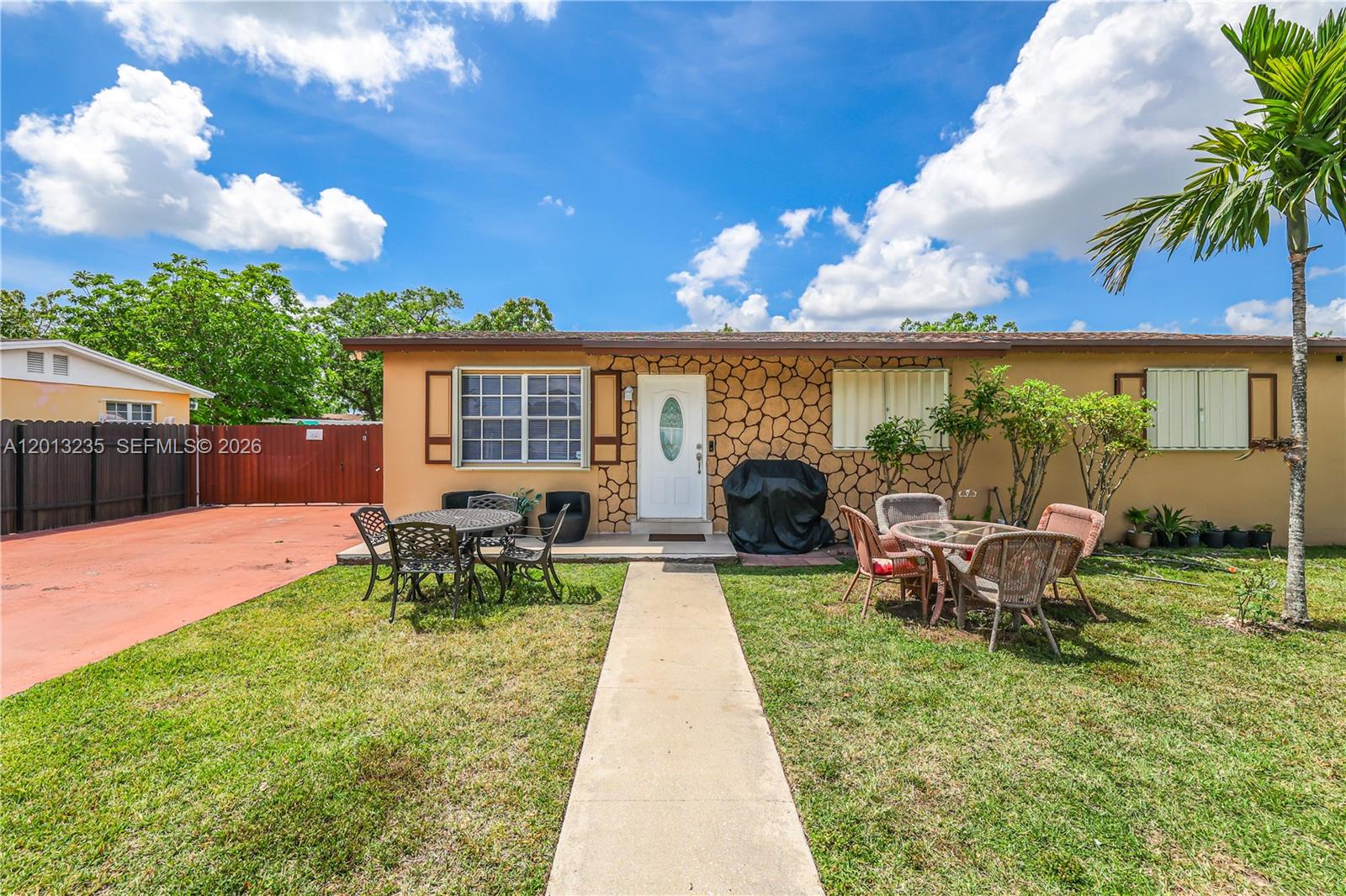 A single-story house with a stone-accented facade, a front walkway, and outdoor patio furniture — 11600 SW 181st Ter, Miami FL 33157, MIAMI, FL