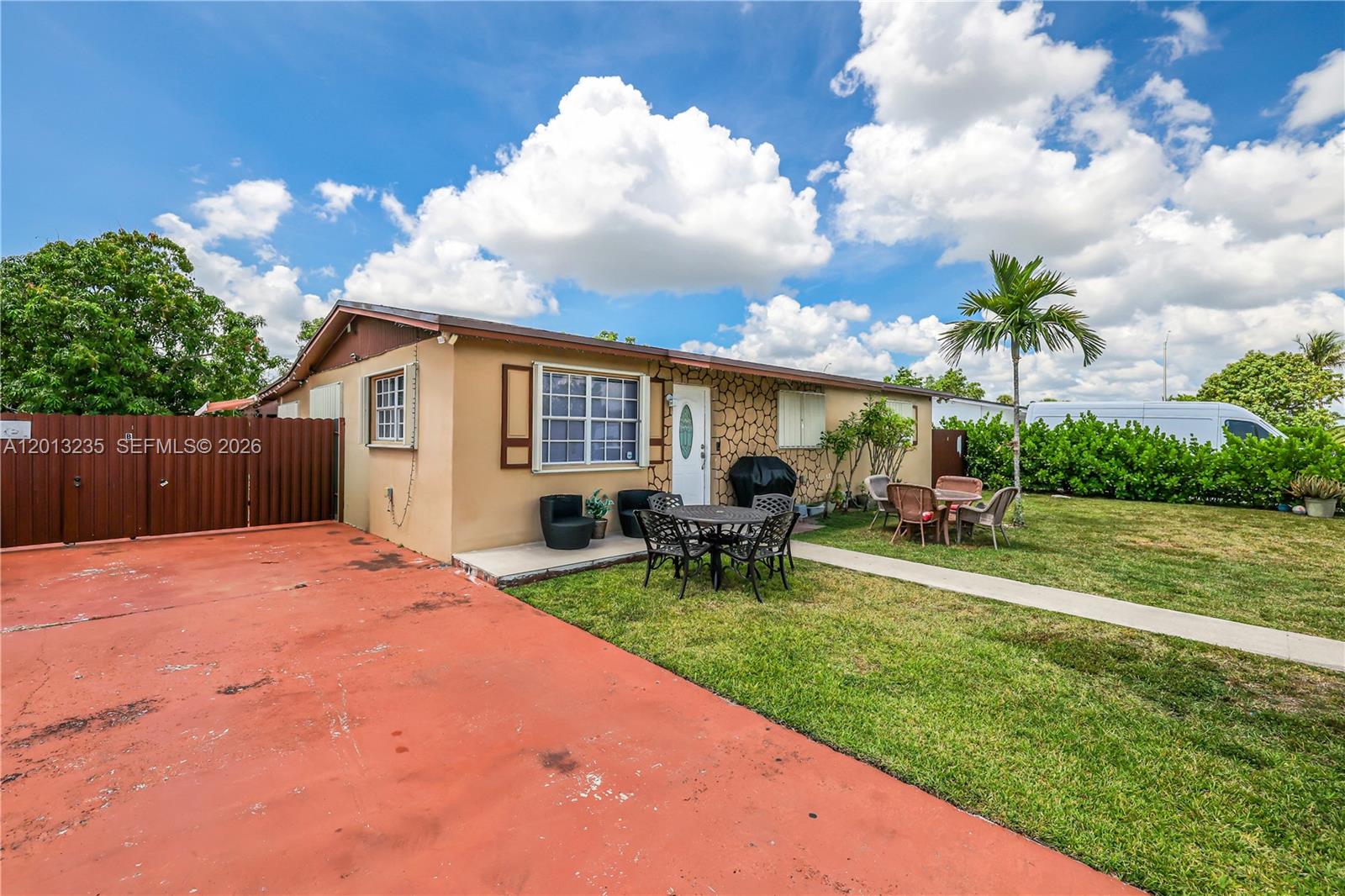 A single-story house with a red driveway, a small patio, and a grassy yard — 11600 SW 181st Ter, Miami FL 33157, MIAMI, FL