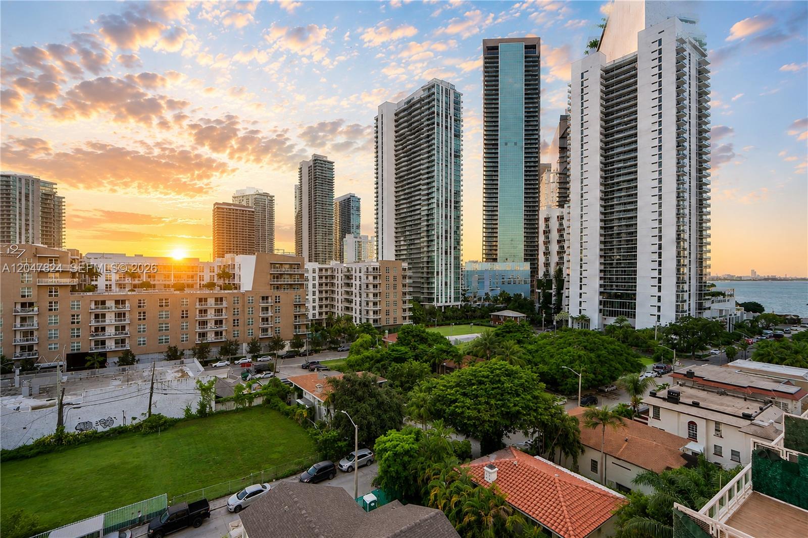 An elevated view of a city skyline featuring high-rise buildings at sunset over a neighborhood — 321 NE 26th St # 806, Miami FL 33137, MIAMI, FL