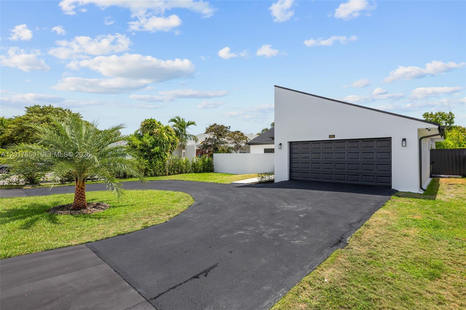 A modern white house with a dark garage door and a curved asphalt driveway — 2851 SW 117th Ave, Miami FL 33175, MIAMI, FL