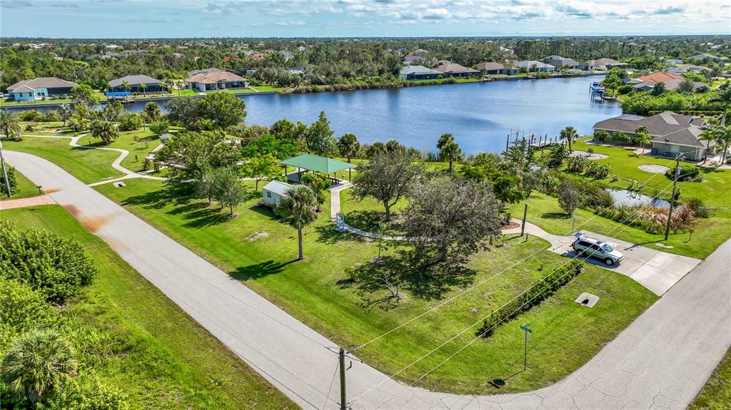 An aerial view shows a park with a pavilion, trees, and a pond in Florida — 10444 PORT EVERGLADES STREET, PORT CHARLOTTE, FL