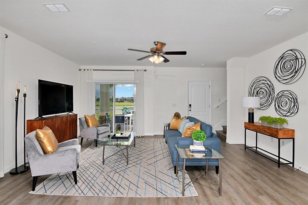 A living room features a blue sofa, two gray armchairs, and a glass coffee table — 2607 HARRIER COURT UNIT Eclipse, APOPKA, FL