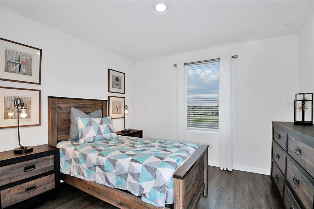 A bedroom features a wooden bed frame, matching nightstands, a dresser, and a window — 2607 HARRIER COURT UNIT Eclipse, APOPKA, FL
