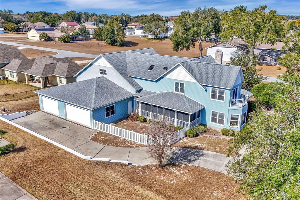An aerial view of a two-story blue house with a garage and screened-in porch — 8900 SE 72ND AVENUE, OCALA, FL