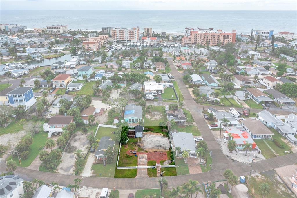 An aerial view shows a residential lot with a small structure and cleared land — 13150 BOCA CIEGA AVENUE, MADEIRA BEACH, FL