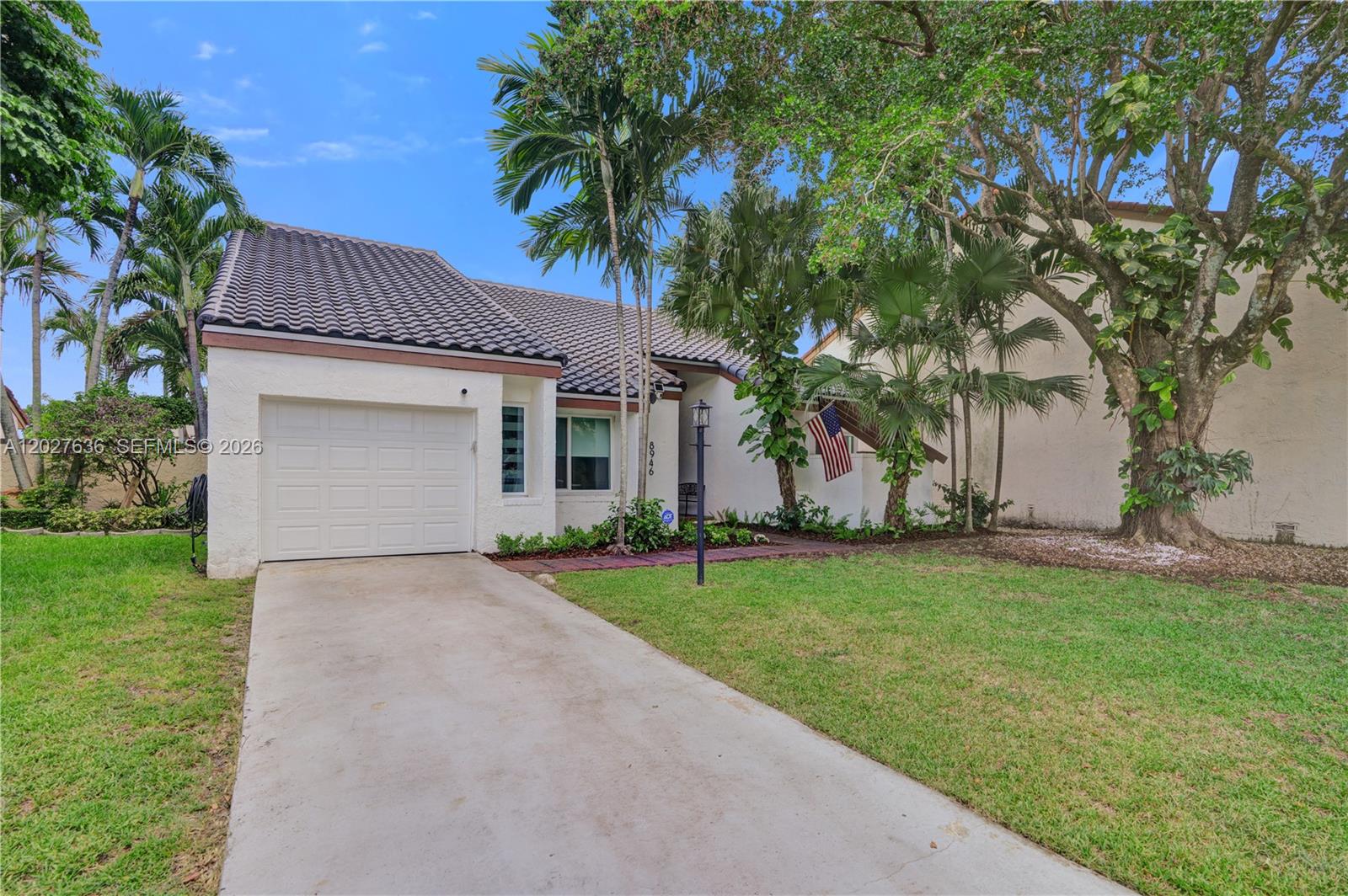 A single-story house with a white stucco exterior, a tiled roof, and a concrete driveway — 8946 SW 150th Ct Cir E, Miami FL 33196, MIAMI, FL