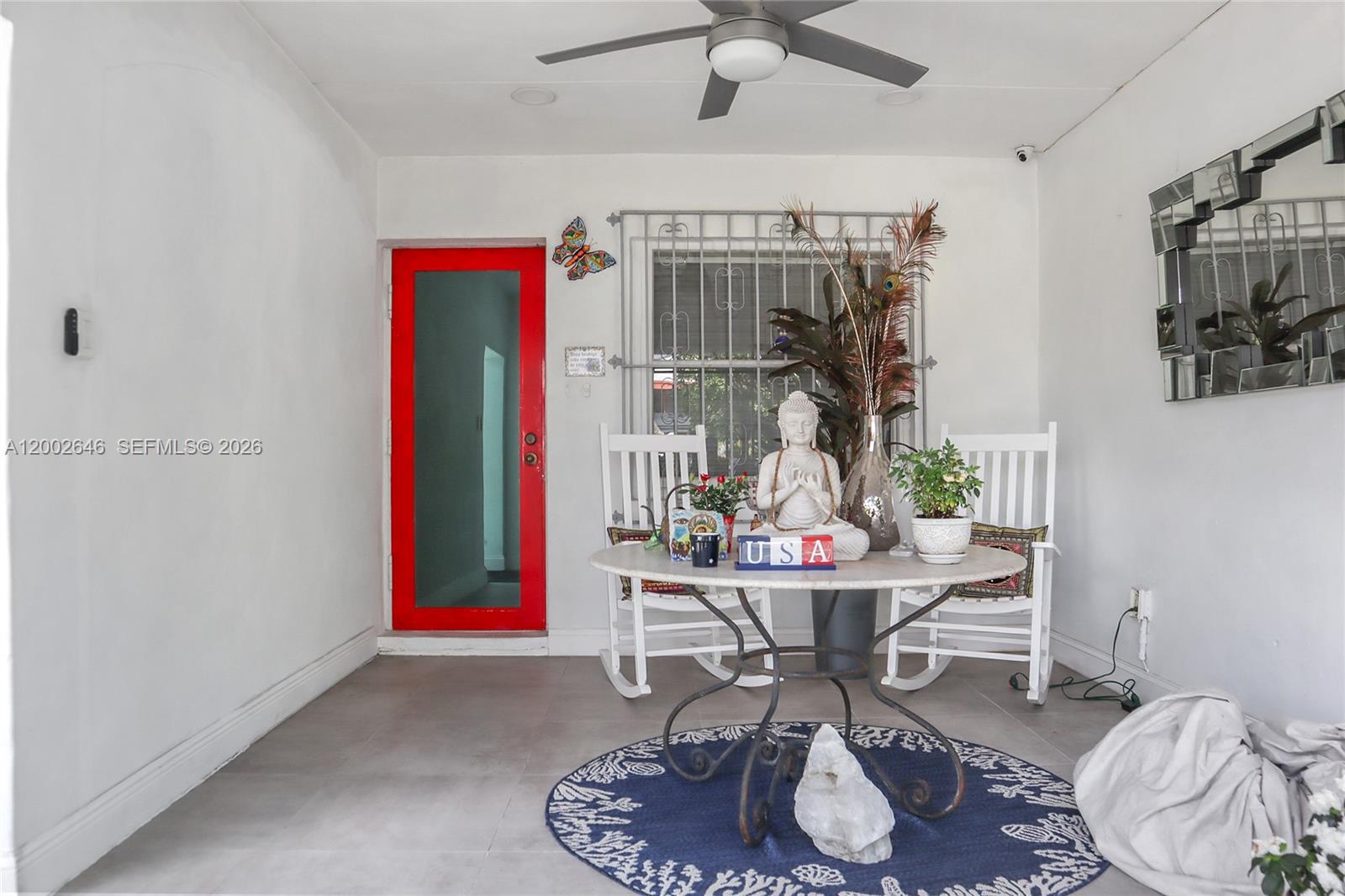 A covered porch features a red door, white rocking chairs, and a round table — 619 SW 39th Ave, Miami FL 33134, MIAMI, FL